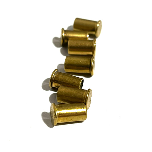 7 empty brass shell casings stacked in a vertical row on a white background