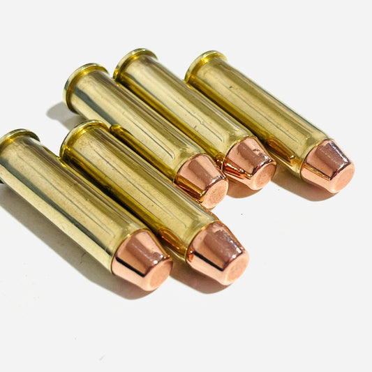 Five spent brass 357 Magnum dummy rounds lying in a group, copper flat-nose bullets facing forward
