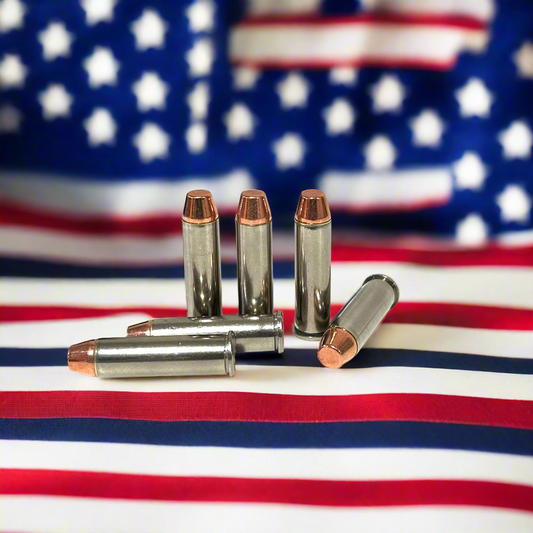 Five nickel fake bullets arranged on an American flag background with three standing upright and two lying down.