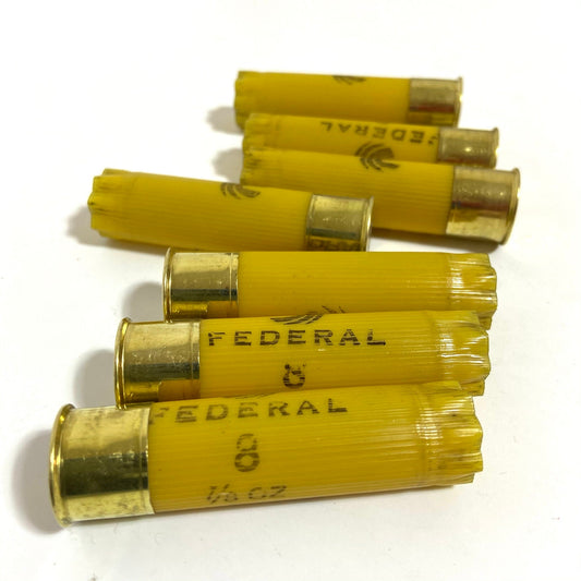 Federal 20 gauge empty shotgun shells, yellow plastic hulls lying flat for creating rustic country-style boutonnières.