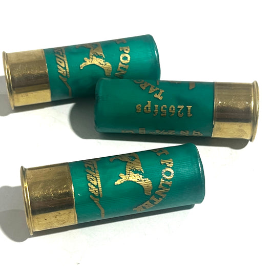 Three green spent shotgun hulls with gold bases and a 1205 fps marking, lying crossed on white