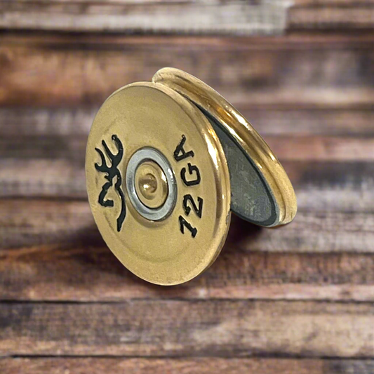 Two gold 12 gauge Browning shotgun shell slices leaning against each other on a wood surface