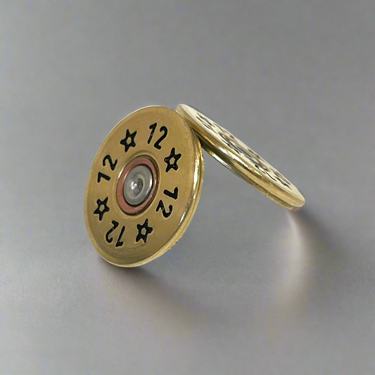 2 round gold brass 12 gauge shotgun shell slices with star and number 12 stamps, one leaning against the other