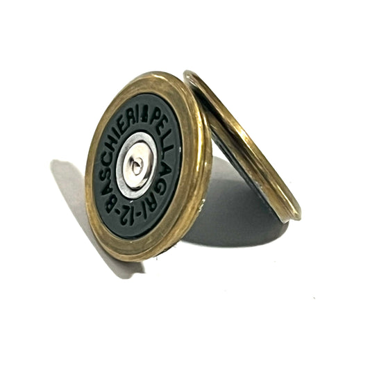 2 round brass shotgun shell slices with green undersides leaning against each other showing headstamp text
