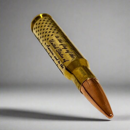 Brass .308 WIN cartridge engraved with the Pledge of Allegiance and a star flag design, tilted on a gray background