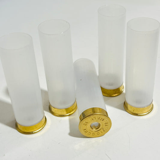 Four translucent unprimed shotgun shells standing upright, with a fifth lying on its side showing its Fiocchi headstamp