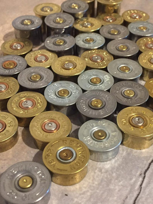 Close-up view of brass and nickel 20 gauge spent shell bases.