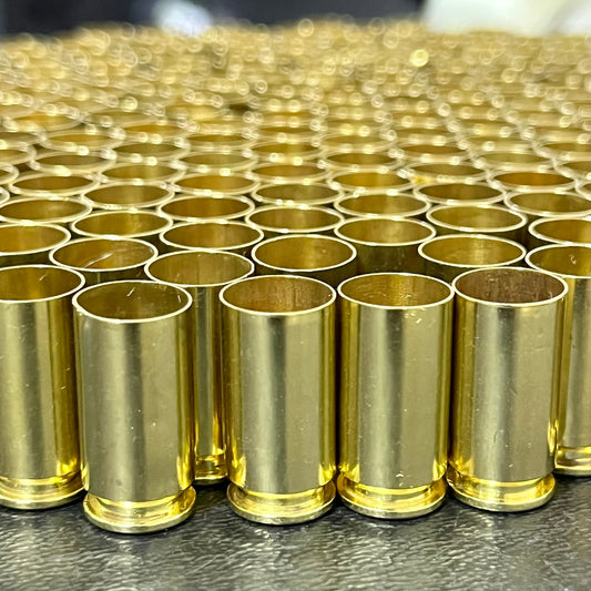 A dense grid of hundreds of polished 40 S&W brass casings standing upright and tightly packed together, showcasing their bright gold finish and open mouths.