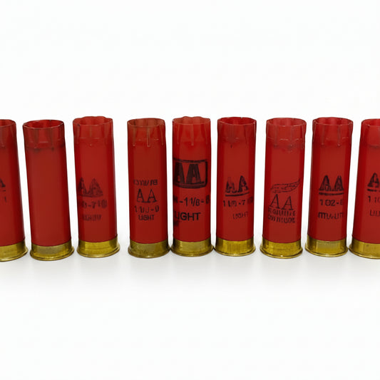 Row of red 12 gauge shotgun used casings with brass ends and AA markings, on a light gray background
