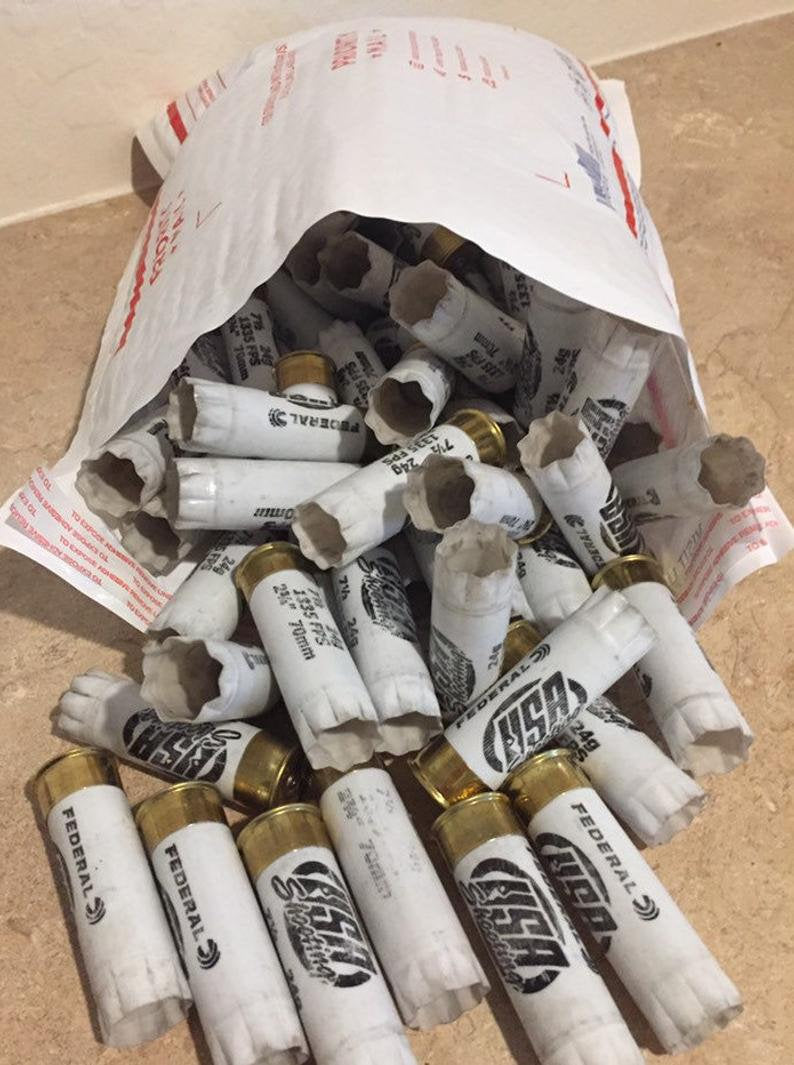 A white paper bag spilling out white Federal and USA Shooting 12 gauge shotgun shells with brass bases