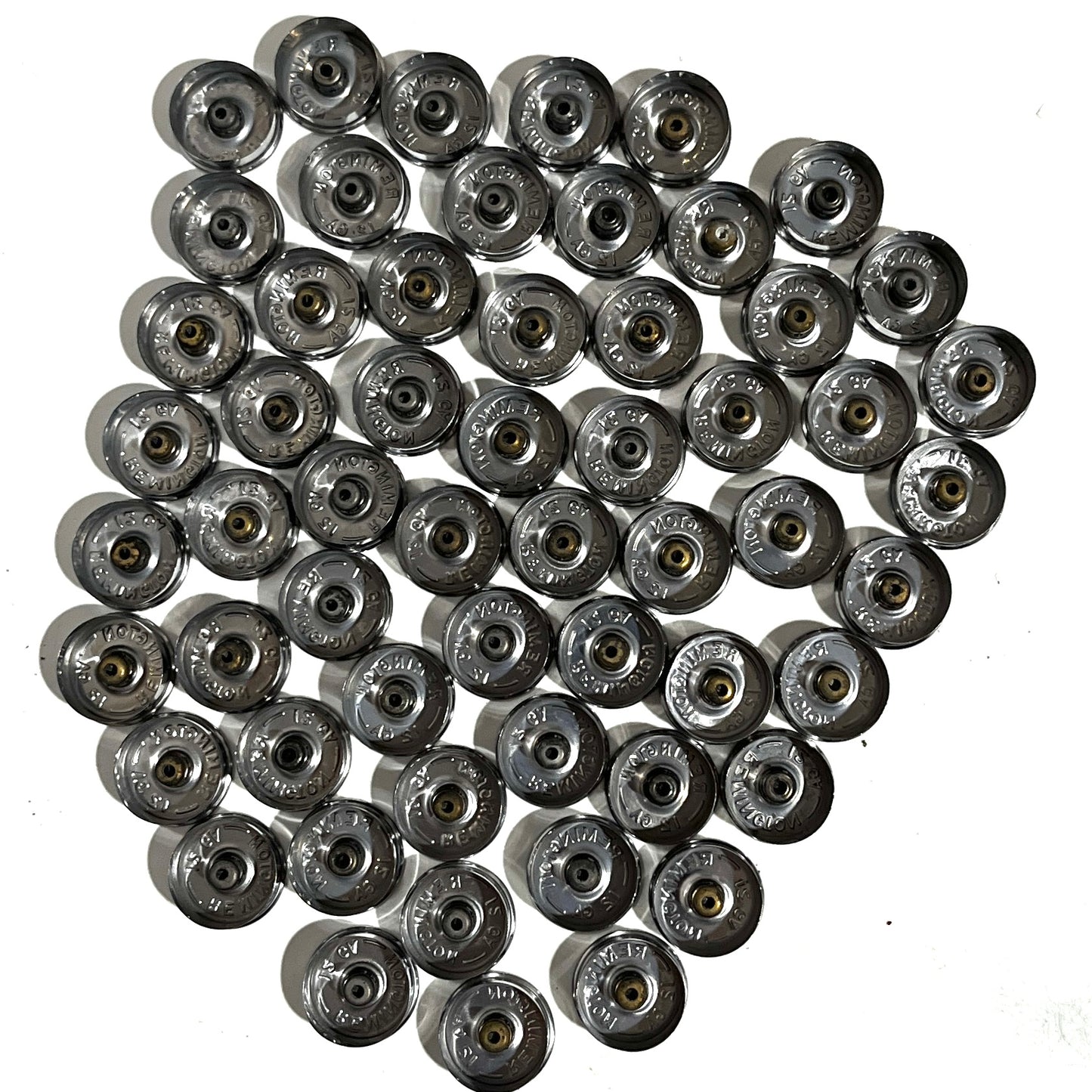 Full set of 50 polished silver 12 gauge shotgun shell bottoms clustered on white background showing stamped underside bases.