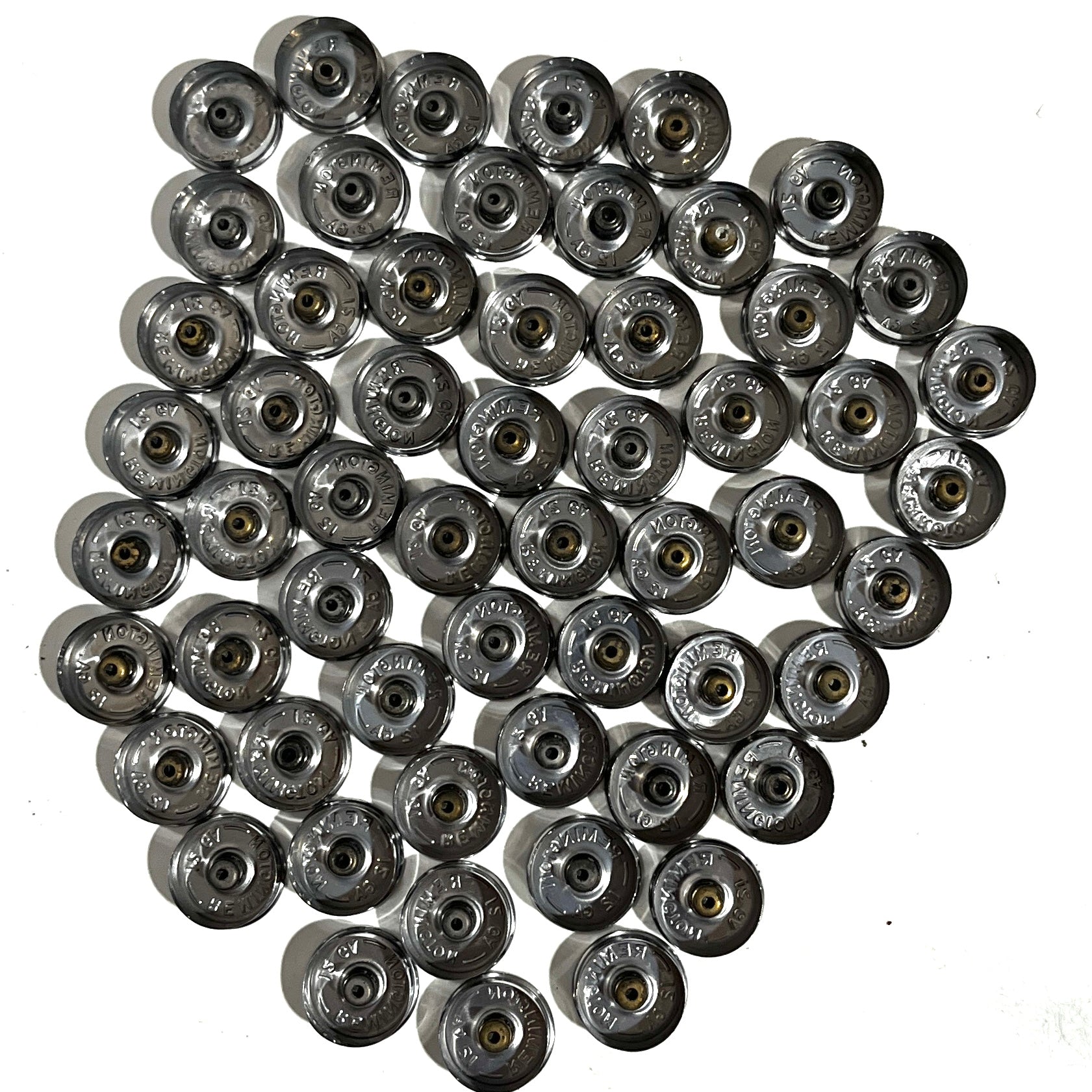 Full set of 50 polished silver 12 gauge shotgun shell bottoms clustered on white background showing stamped underside bases.
