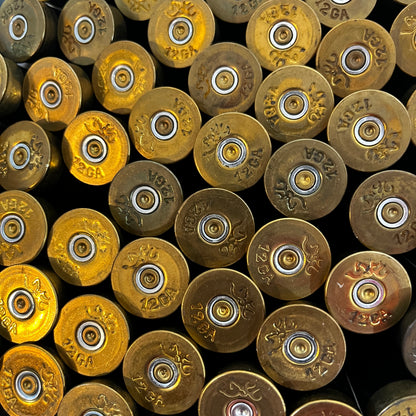Close-up of brass 12 gauge shotgun shell base caps stamped 12GA Made in USA, viewed from above