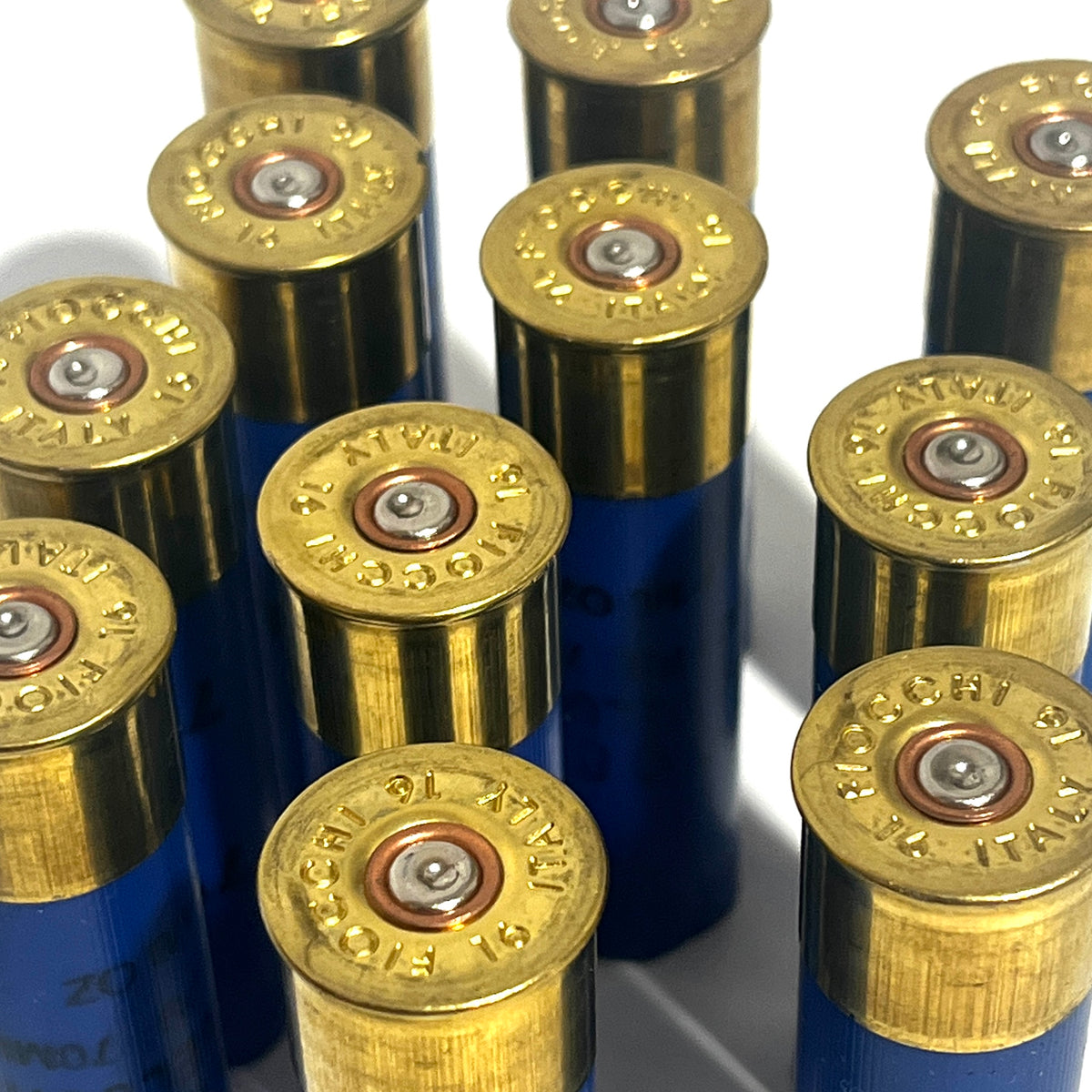 Cluster of blue 16 gauge Fiocchi Italy empty shotgun shells with gold high brass bases viewed base-up