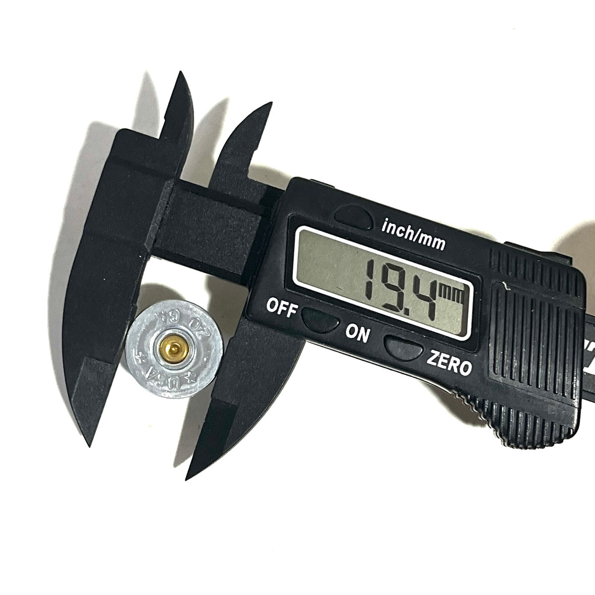 Digital caliper measuring a silver 20 gauge shotgun shell slice's diameter at 19.4 millimeters