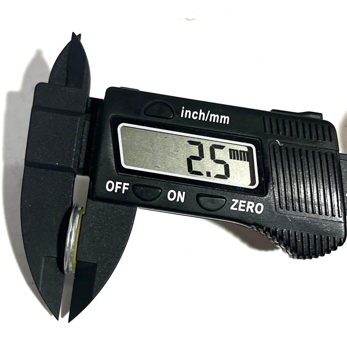 Digital caliper measuring a 20 gauge shotgun shell slice's thickness at 2.5 millimeters