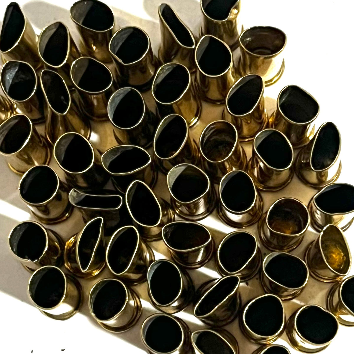 Close-up top-down view of empty brass shell casings with black interiors clustered together