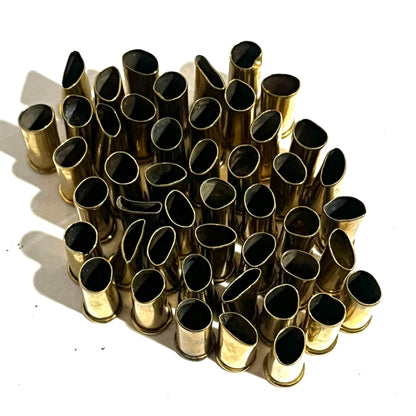 Rows of empty brass shell casings with black interiors standing open end up in neat rows