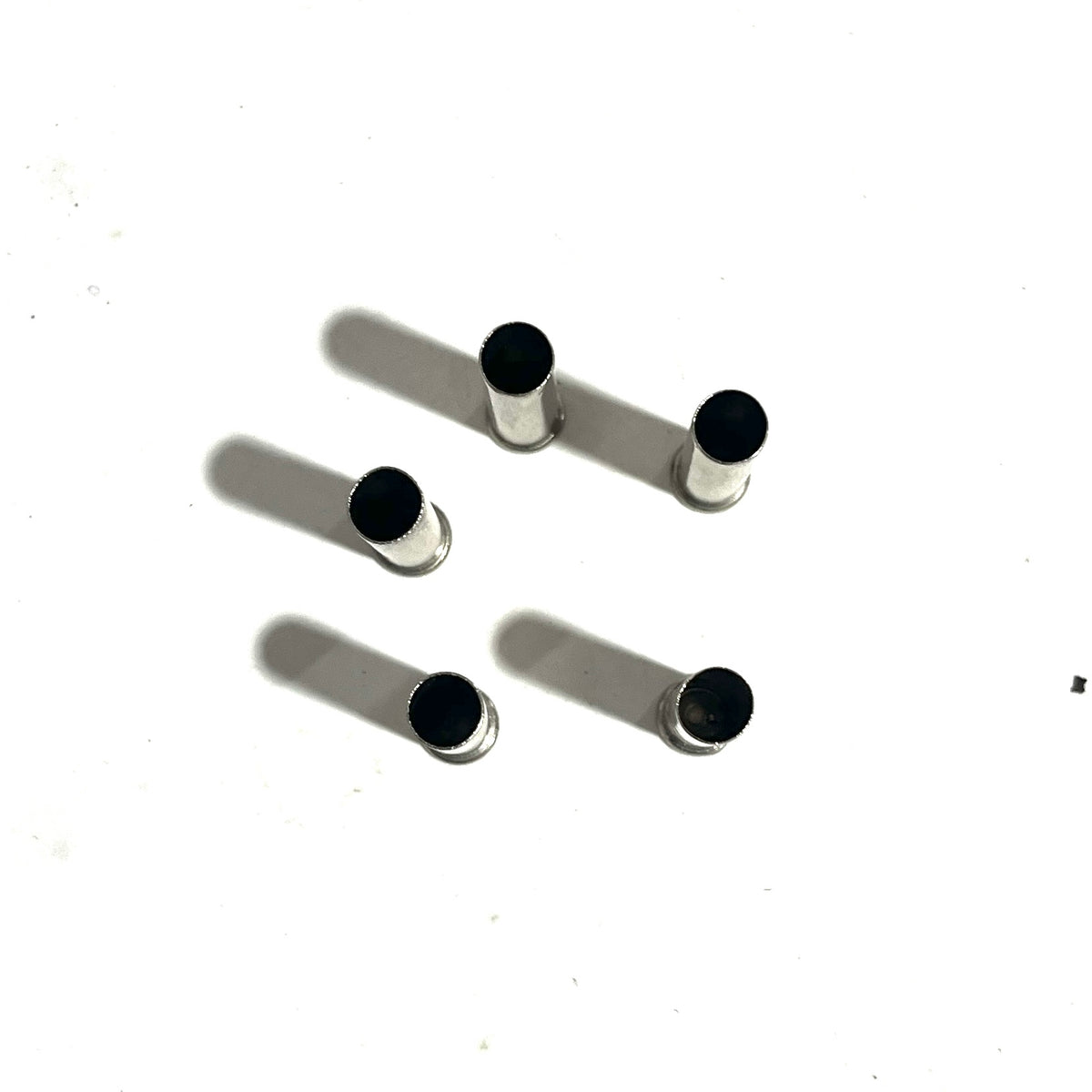 5 empty nickel .22 caliber spent shells viewed from above showing open case mouths on a white background