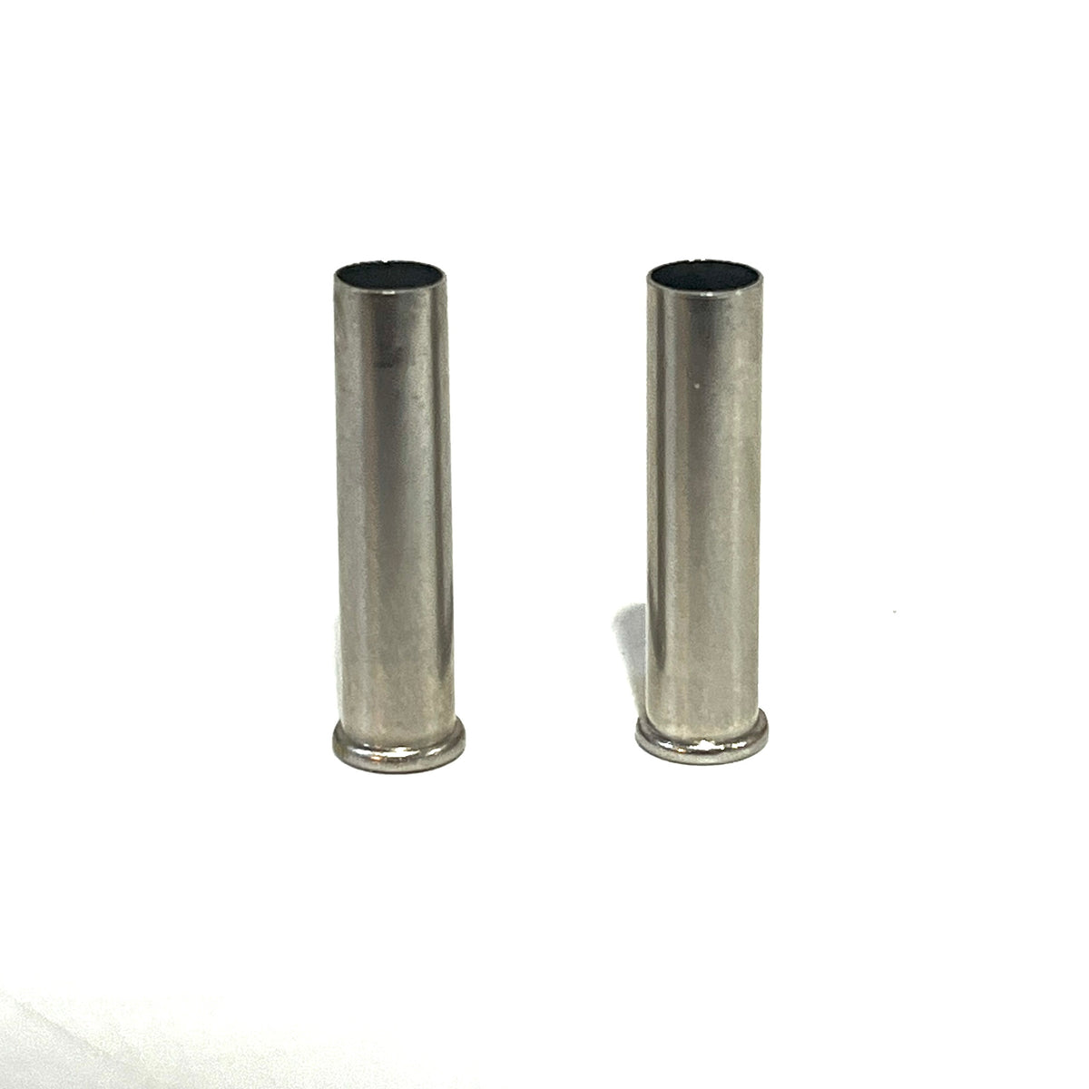 2 empty nickel .22 caliber fired shells standing upright with open case mouth ends on a white background