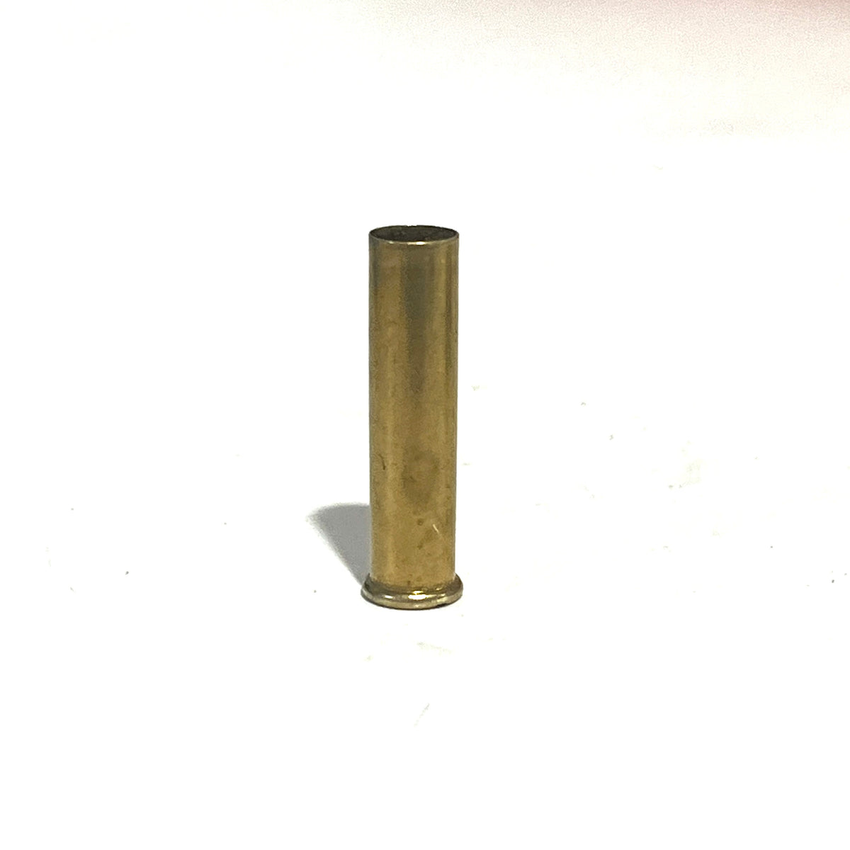 A single brass 22 caliber WMR shell standing upright on a white background