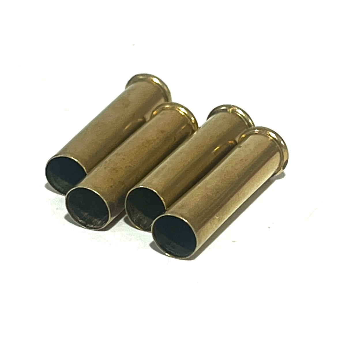 Four brass 22 caliber WMR shells lying together on a white background
