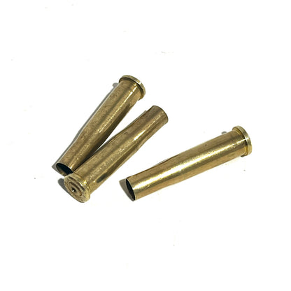 3 brass .22 Hornet shell casings lying on a white background