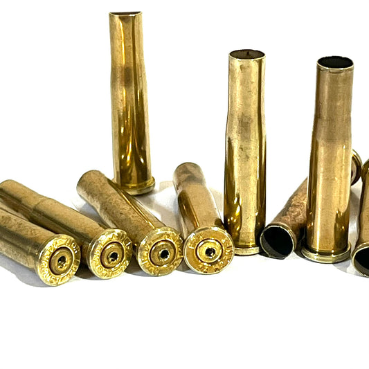 Group of brass .22 Hornet shells, some standing upright and some lying down, showing drilled headstamp ends and open mouths