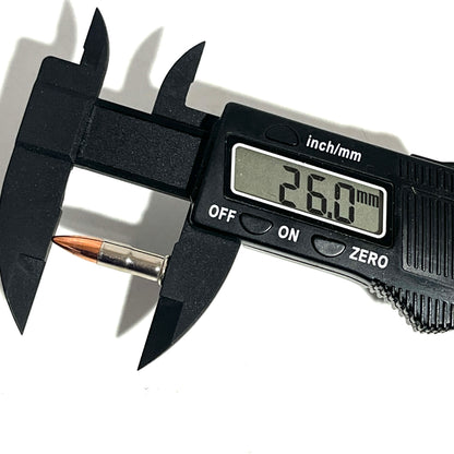 Digital caliper measuring a .22 caliber nickel dummy round's overall length at 26.0 millimeters