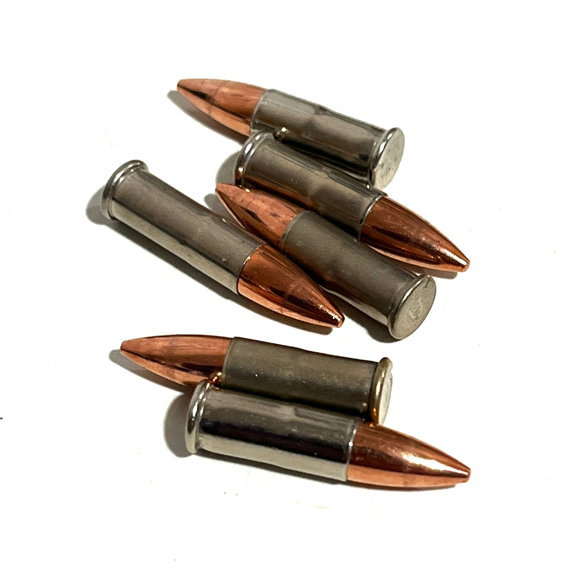 5 .22 caliber nickel dummy rounds lying on a white background
