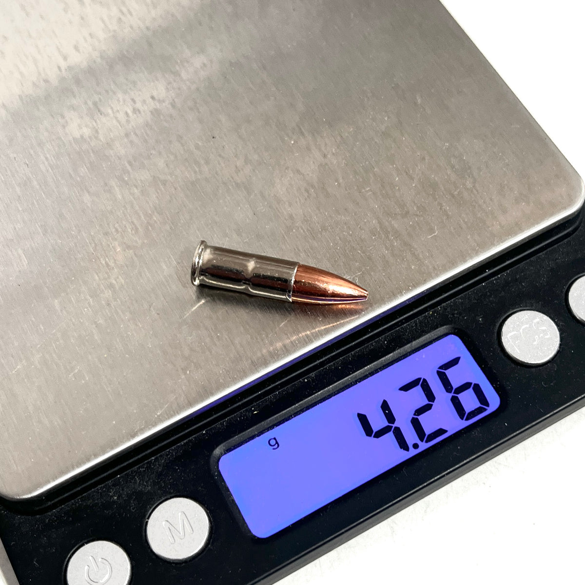 .22 caliber nickel dummy round on a digital scale reading 4.26 grams