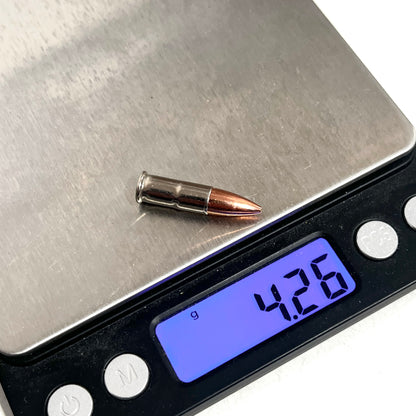 .22 caliber nickel dummy round on a digital scale reading 4.26 grams