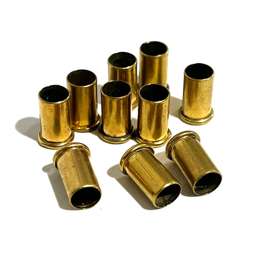 10 empty brass shell casings standing and lying scattered on a white background