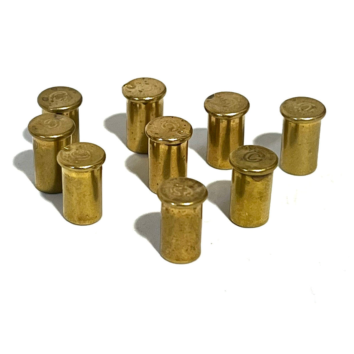 8 empty brass shell casings standing upright showing headstamps on a white background