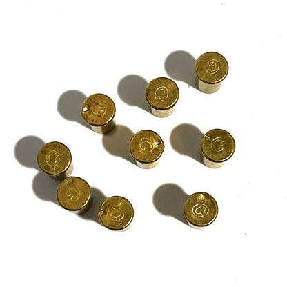 8 brass shell headstamps viewed from above showing C markings on a white background