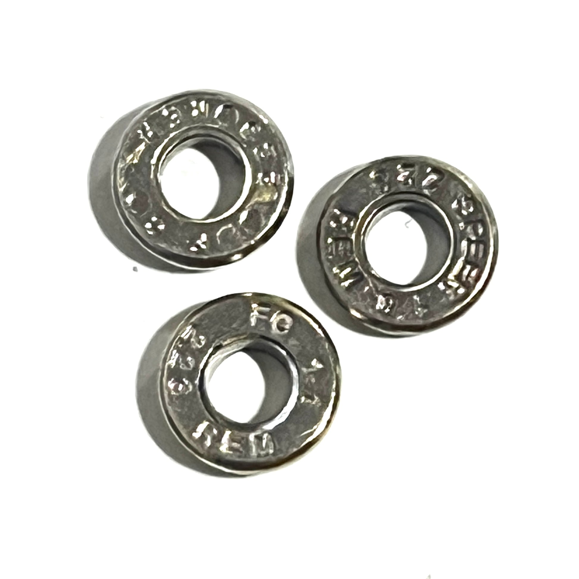 Three deprimed .223/5.56 nickel casing slices with visible headstamps, arranged on a white background.