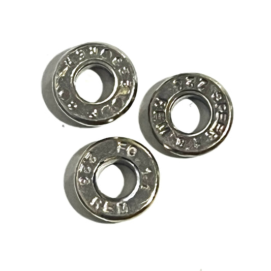 Three deprimed .223/5.56 nickel casing slices with visible headstamps, arranged on a white background.