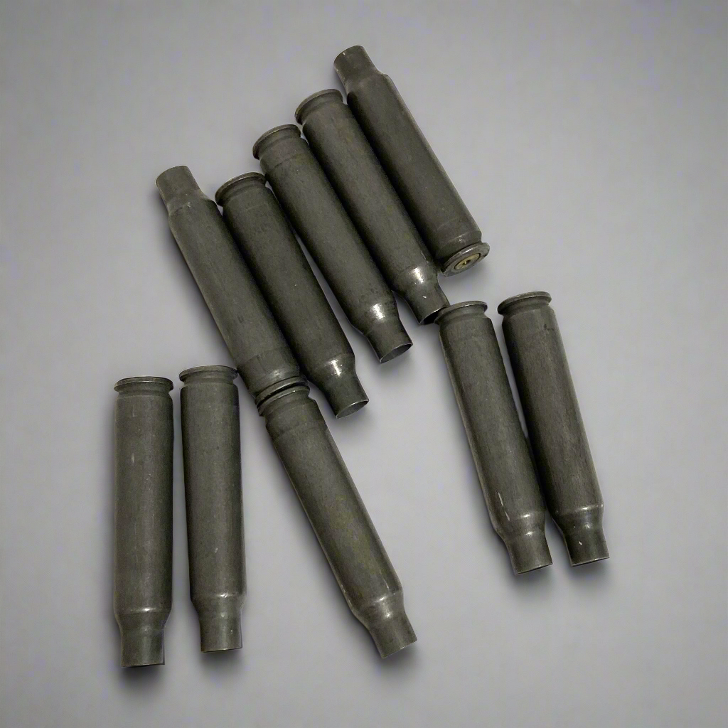 10 gray steel .223/5.56 spent casings arranged in rows on gray background