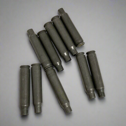 10 gray steel .223/5.56 spent casings arranged in rows on gray background