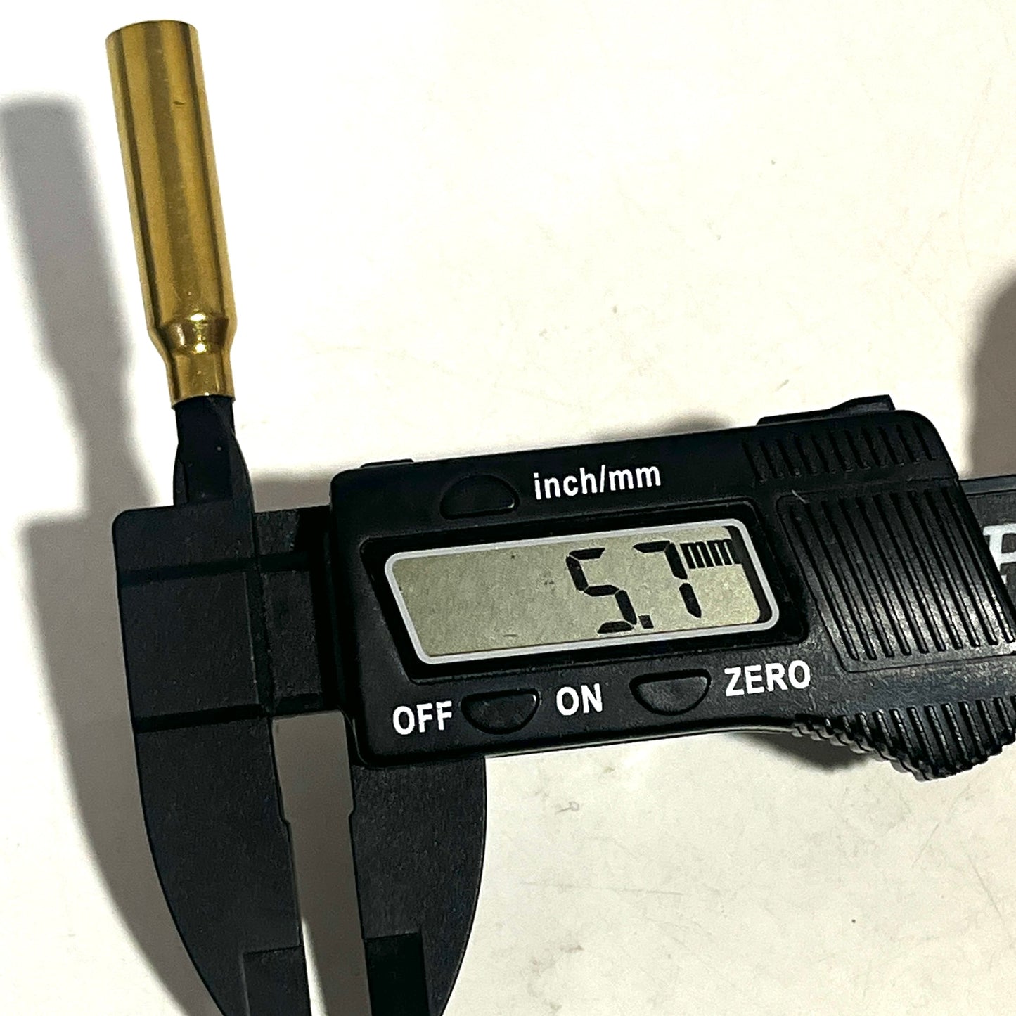 A .223 brass bullet casing bead measured with digital calipers showing a 5.7mm opening