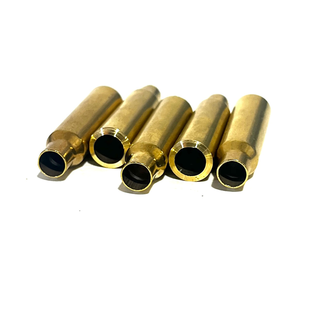 Five .223 brass bullet casing beads lying in a fanned row with open cut ends facing forward