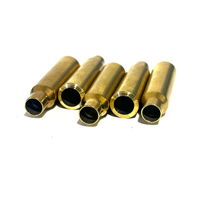 Five .223 brass bullet casing beads lying in a fanned row with open cut ends facing forward