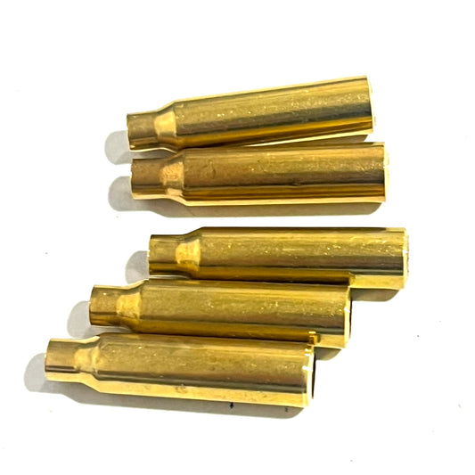 Five .223 brass bullet casing beads lying on their sides showing the tapered case body