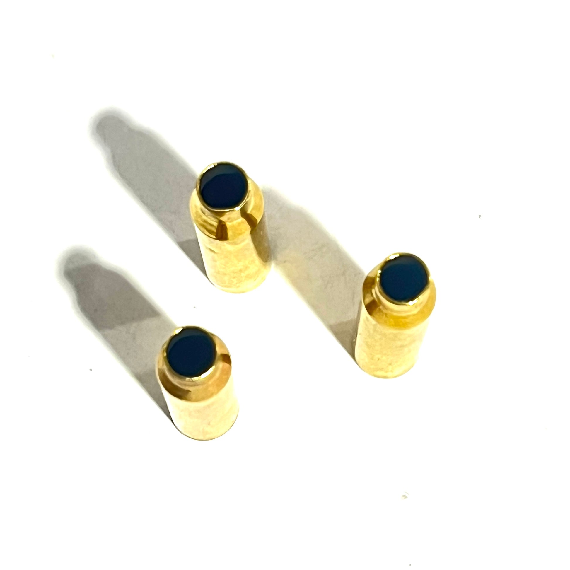 Three .223 brass bullet casing beads viewed from above showing the open  end