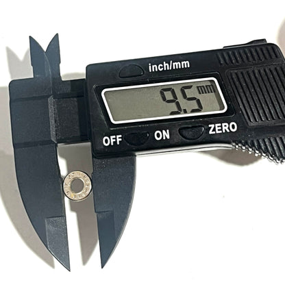 A used nickel cartridge slice beside a digital caliper displaying a 9.5 mm diameter reading.