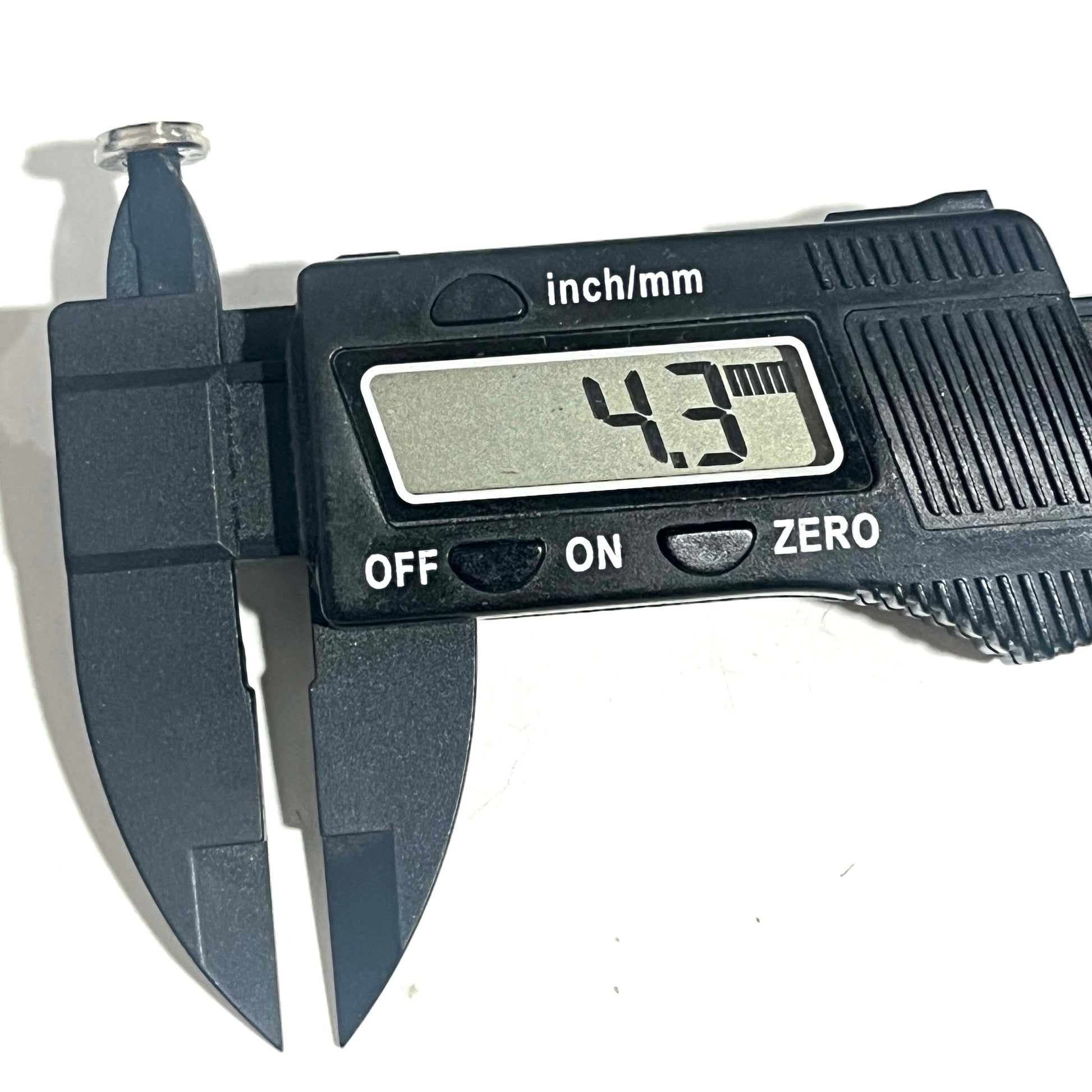 A spent nickel casing slice with its inner hole measured by caliper at 4.3 mm.