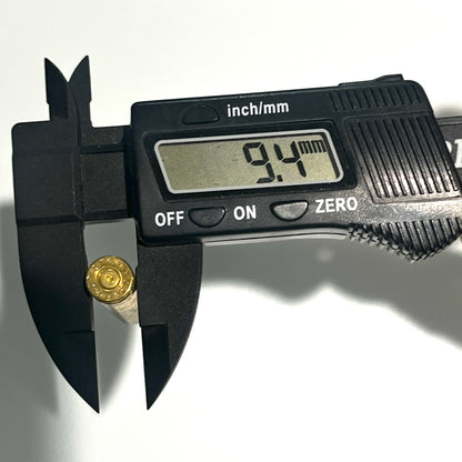 Digital caliper measuring a dirty realistic  .223 brass dummy round casing base, reading 9.4mm