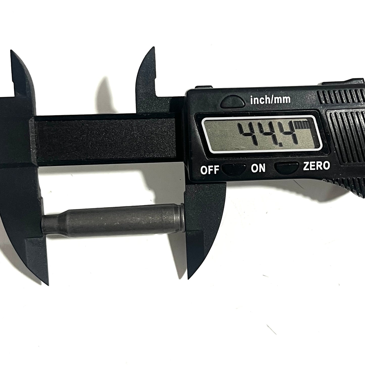 A digital caliper measures a spent 223 gray steel cartridge's length, reading 44.4 mm.