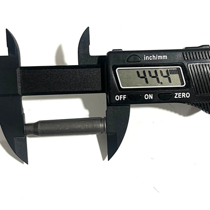 A digital caliper measures a spent 223 gray steel cartridge's length, reading 44.4 mm.