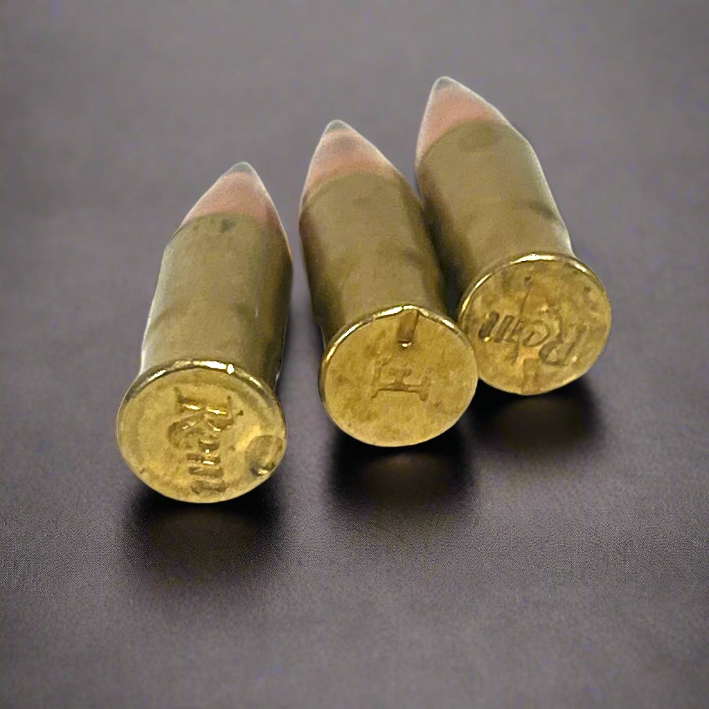 3 .22 caliber dummy rounds with black polymer bullet tips, viewed from the base showing Remington headstamps